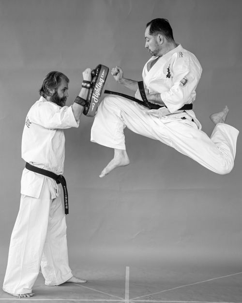 Free Black and white photo capturing a high-flying karate kick in a training session. Stock Photo