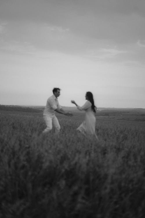 Black and White Photo of a Couple in a Field 