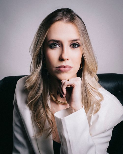 Free Sophisticated portrait of a blonde woman in a white jacket, showcasing elegance and style. Stock Photo