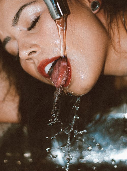 Woman Drinking Water from a Tap 