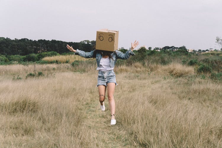 Funny Woman Jumping With Cardboard Box On Head