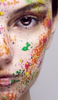 Close-up of a colorful painted face with artistic creativity on a white background.