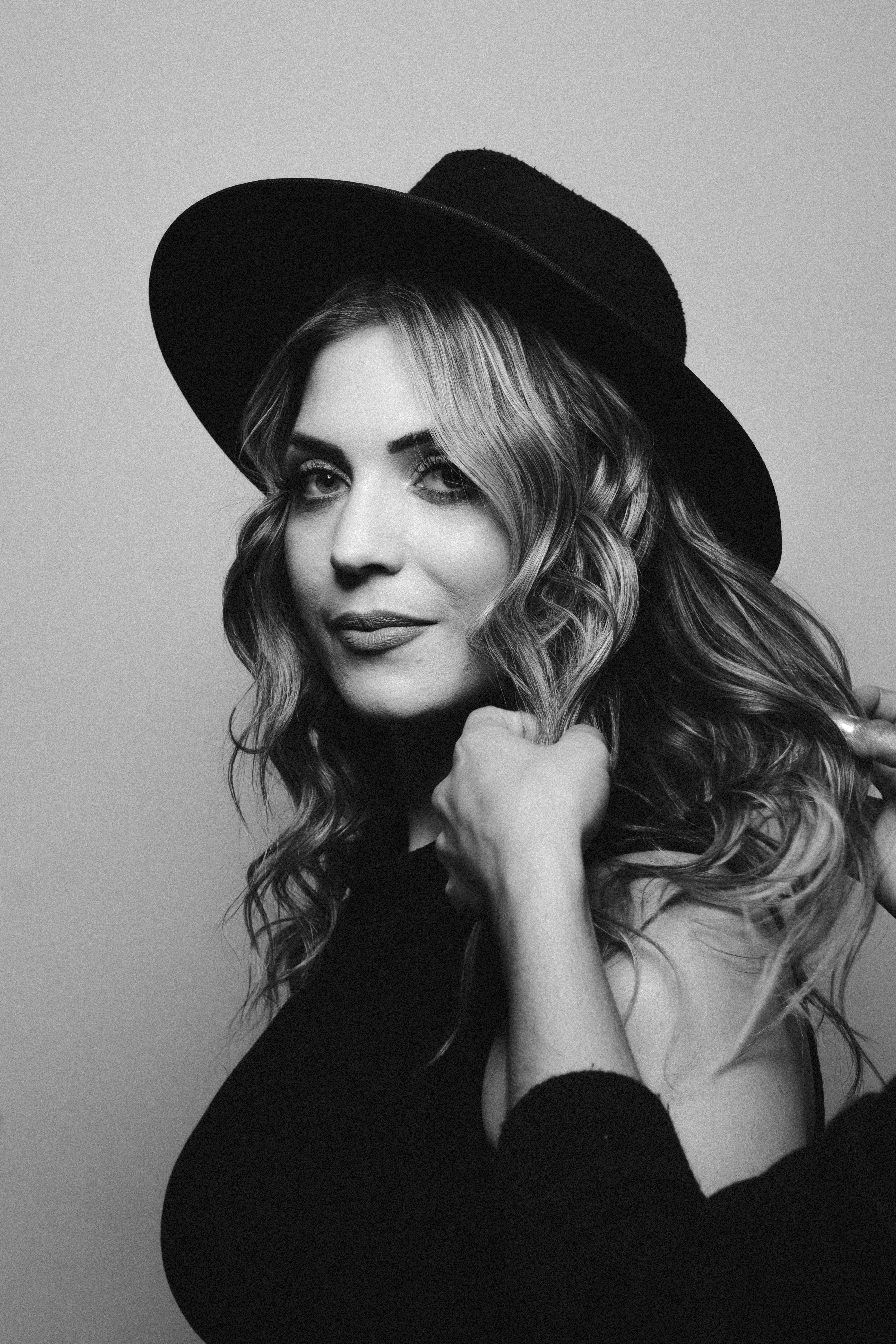 Stylish black and white portrait of a woman in a classic hat exuding elegance and sophistication.