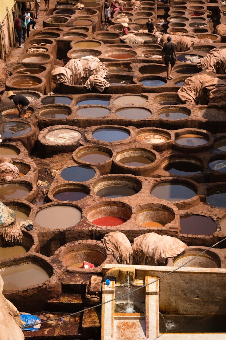 Workers Among Containers With Liquids And Paints