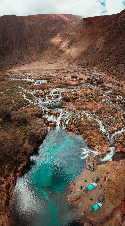 Free Breathtaking aerial shot of Huancaya's waterfalls cascading into a turquoise river. Stock Photo