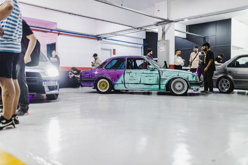 Free A vibrant display of custom cars and enthusiasts at an indoor automotive event. Stock Photo