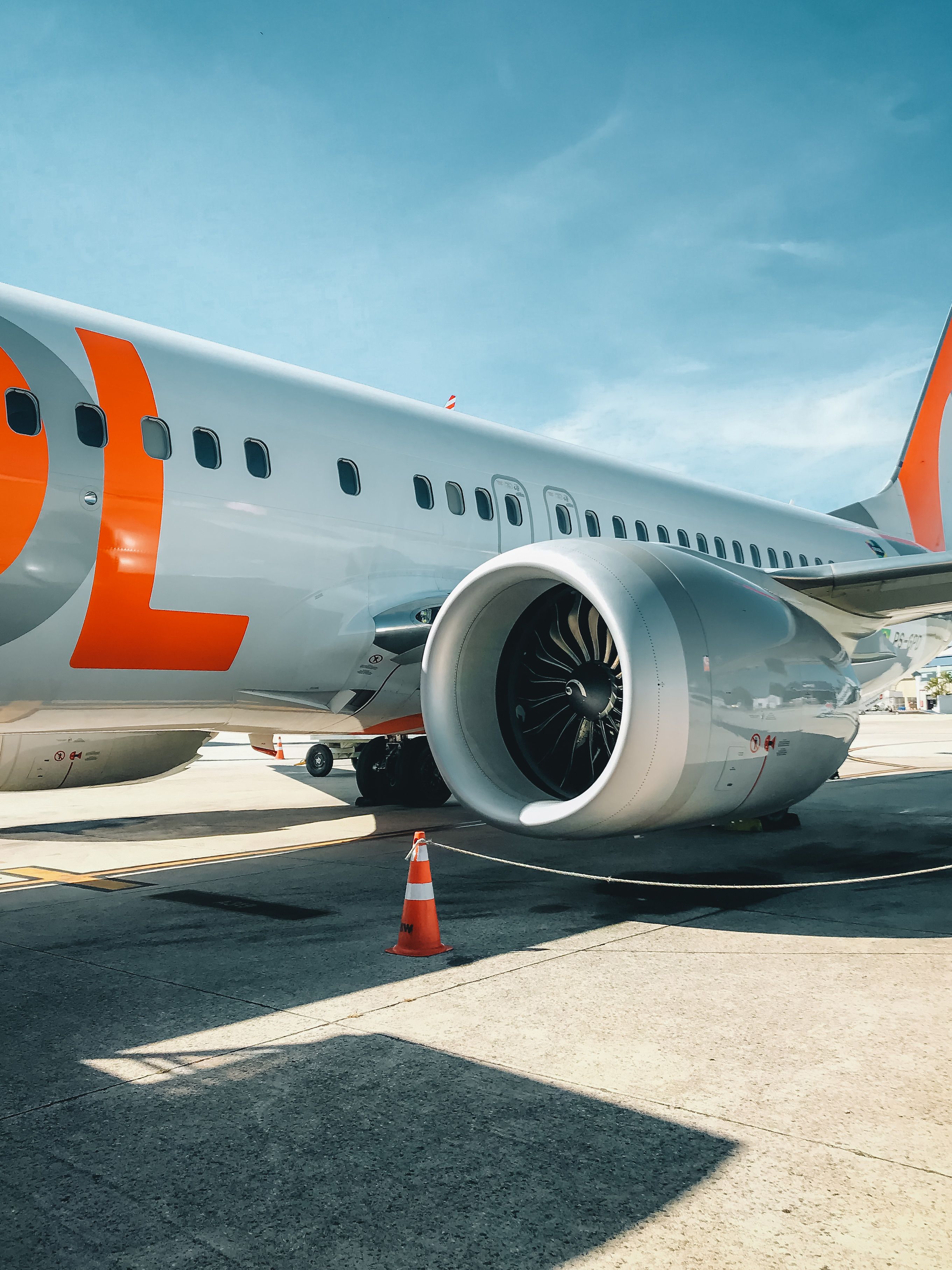 Close-up view of a modern passenger airplane on an airport runway under a clear sky.