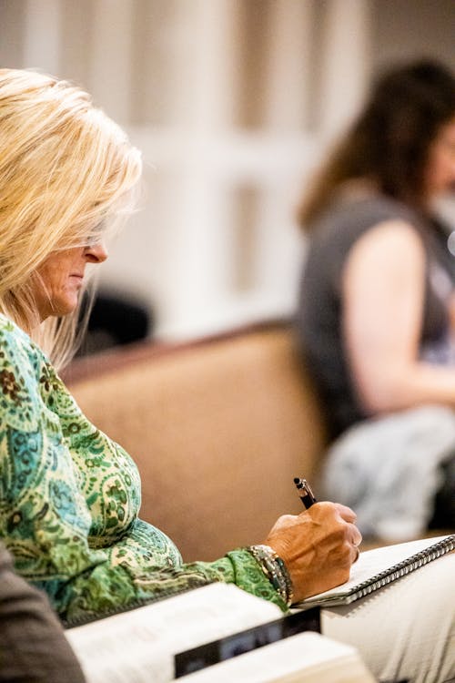 Woman Sitting on Class and Making Notes