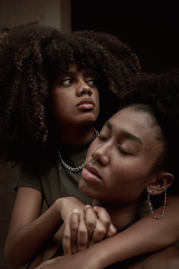 Young Women With Afro Hair Sitting Close Together 