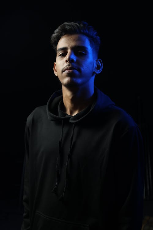 Portrait of Young Man Posing on Black Background