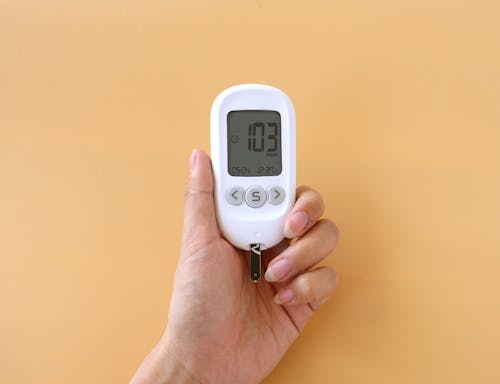 A person holding a digital blood sugar meter