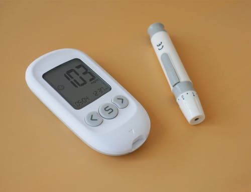 A digital blood sugar meter and a pen