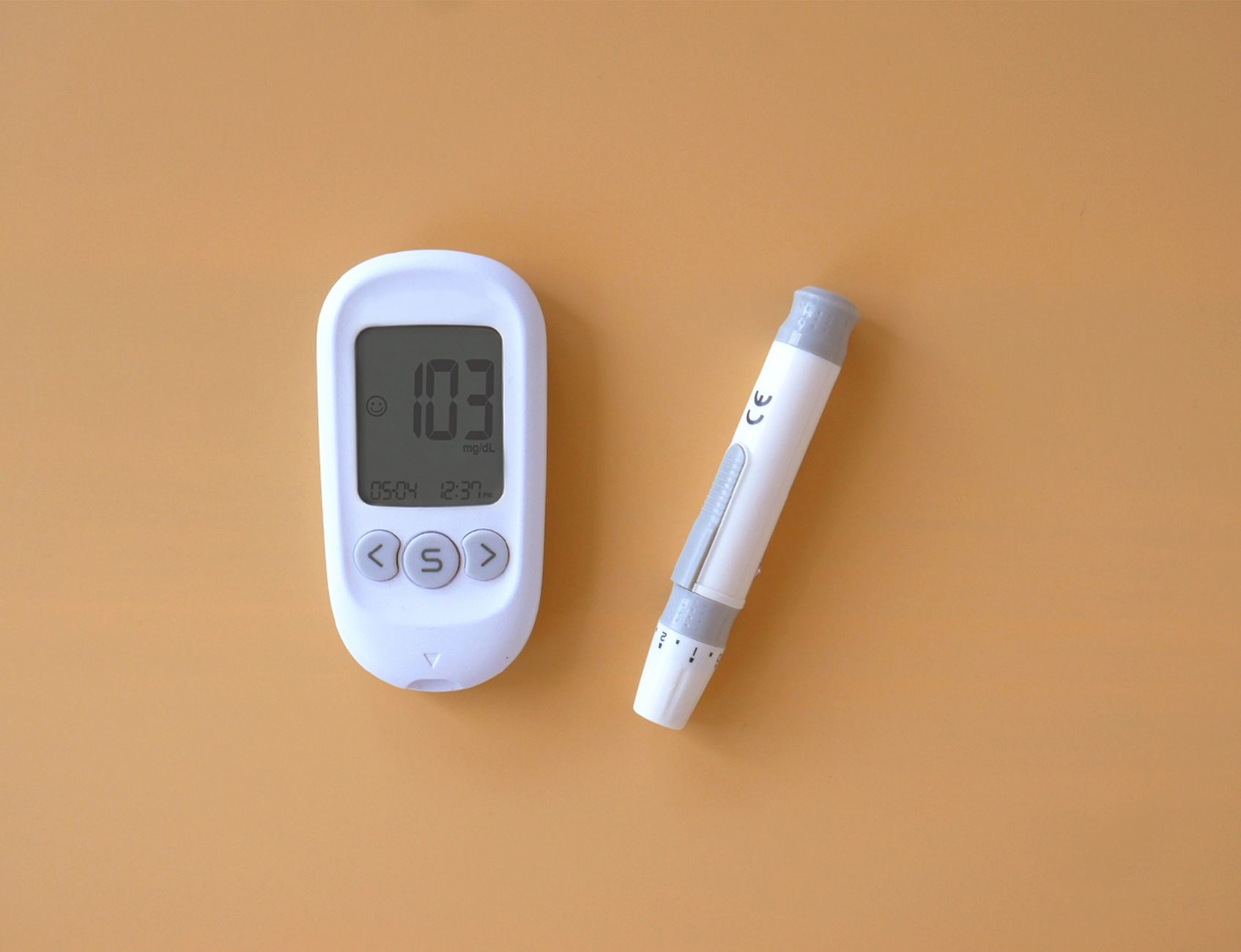 고혈압도 안심! 2025년 가입 가능한 보험, 현명하게 선택하는 비법 5 Close-up of a blood glucose meter and lancet on an orange surface, symbolizing health monitoring in diabetes care.