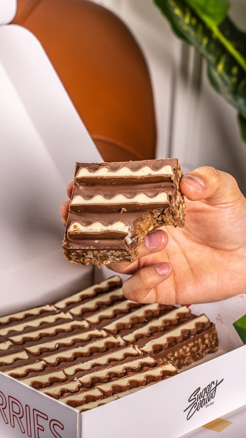 Closeup of a Hand Holding a Slice of a Layered Cake