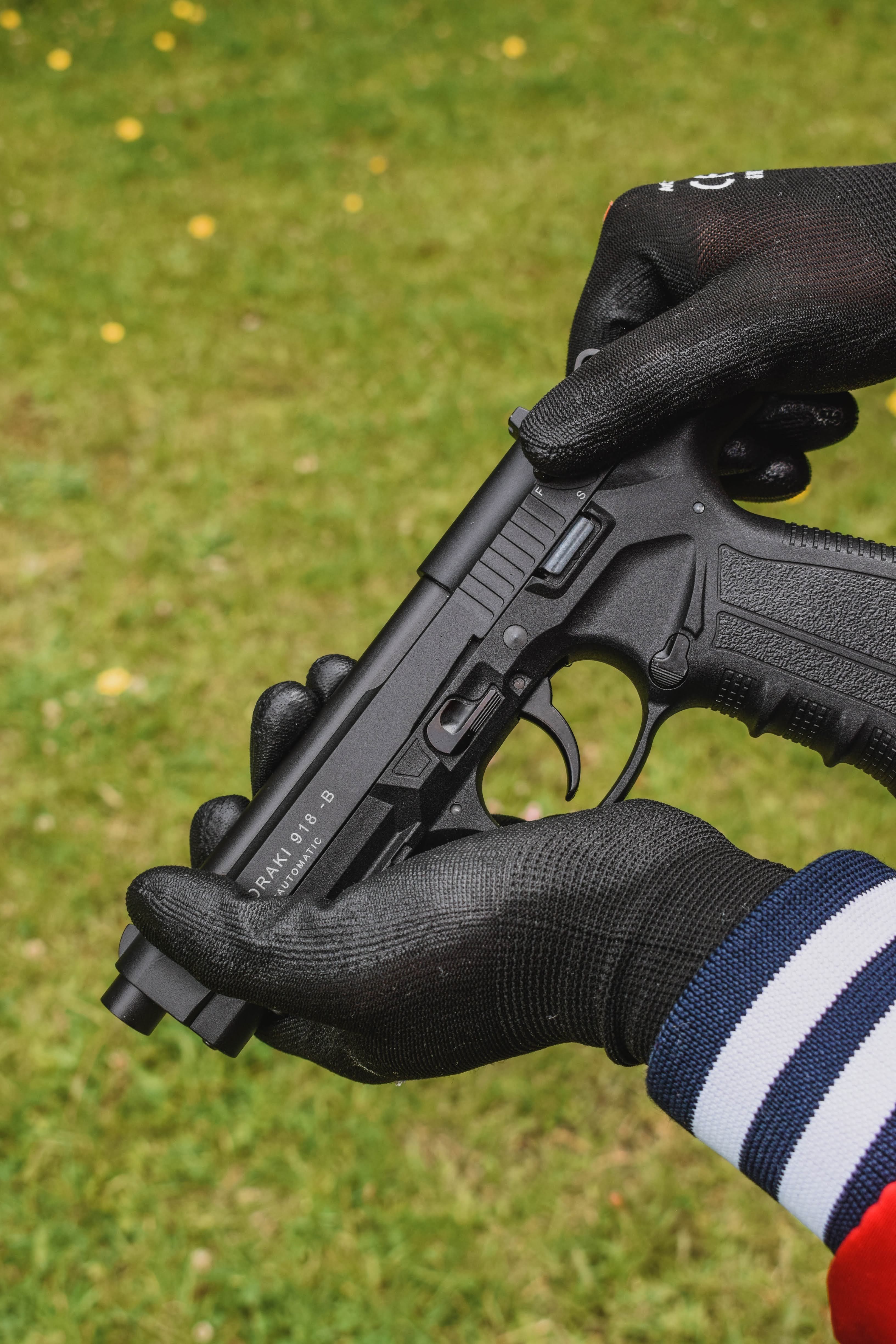 Photo of Gloved Hands Holding a Gun · Free Stock Photo