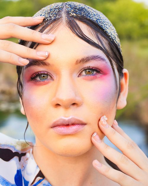 Free Creative portrait of a woman with vibrant makeup and glitter detail, emphasizing beauty and expression. Stock Photo