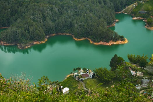 A stunning aerial shot of Guatape reservoir showcasing vibrant green waters and lush forests.