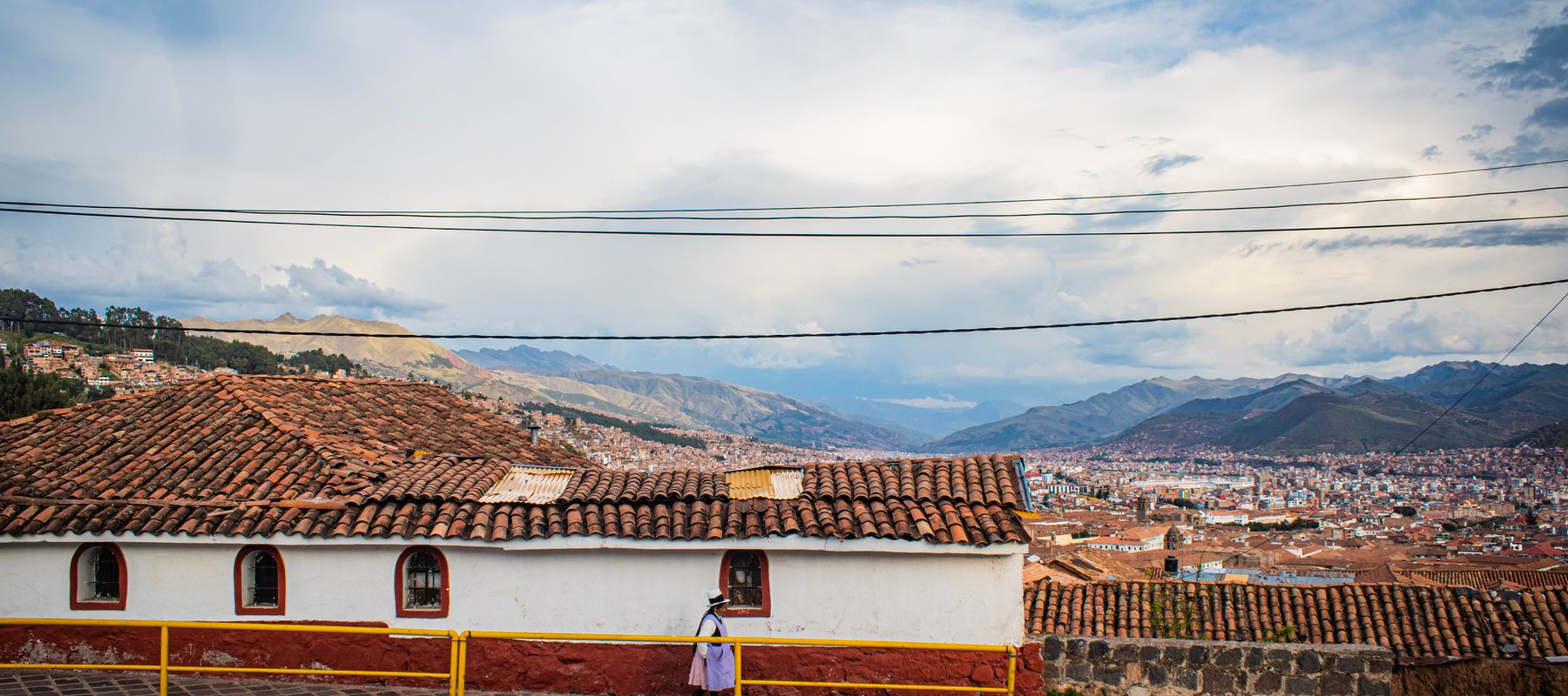 Explore Cusco's scenic cityscape with traditional rooftops and expansive mountain views.
