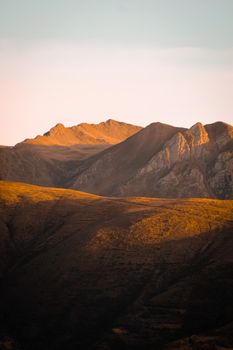 Breathtaking view of the Andes mountains during sunset in Ayacucho, Peru, capturing golden hues and rugged peaks.