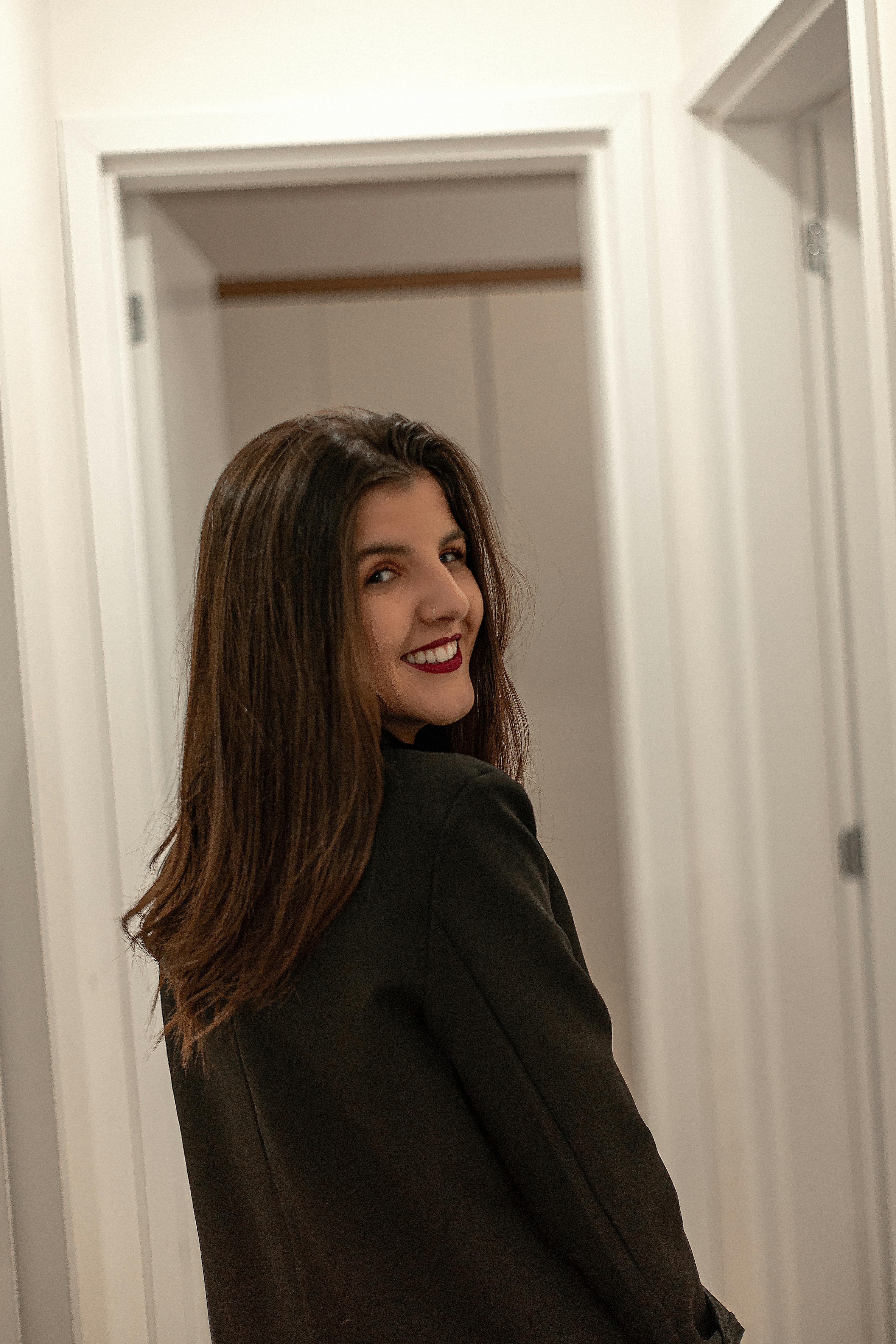 Portrait of a young woman in a hallway smiling back at the camera.