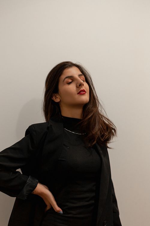 Free Stylish woman in black outfit with red lips and closed eyes, striking a pose. Stock Photo