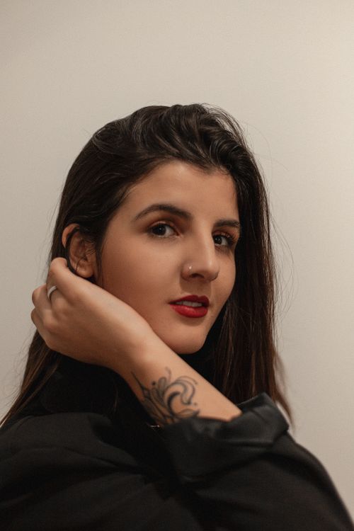 Free Close-up portrait of a woman with tattoos and natural makeup in a studio setting, Brazil. Stock Photo