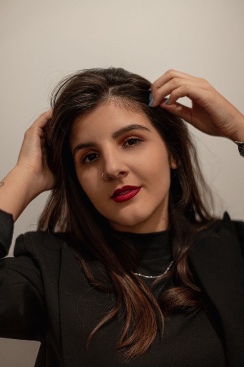 Free Stylish young woman with red lips in a black outfit, posing confidently indoors. Stock Photo