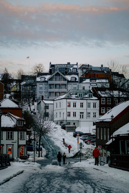 Free Charming winter scene on a snowy street in Trondheim, Norway, with pedestrians and classic architecture. Stock Photo