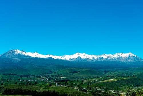 Landscape of a Green Valley and Snowcapped Mountains 