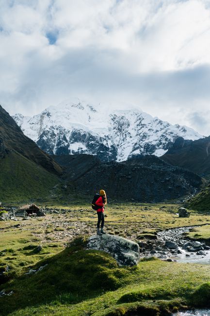 Woman hiker with backpack admiring the snowcapped Andes in the Cusco region.