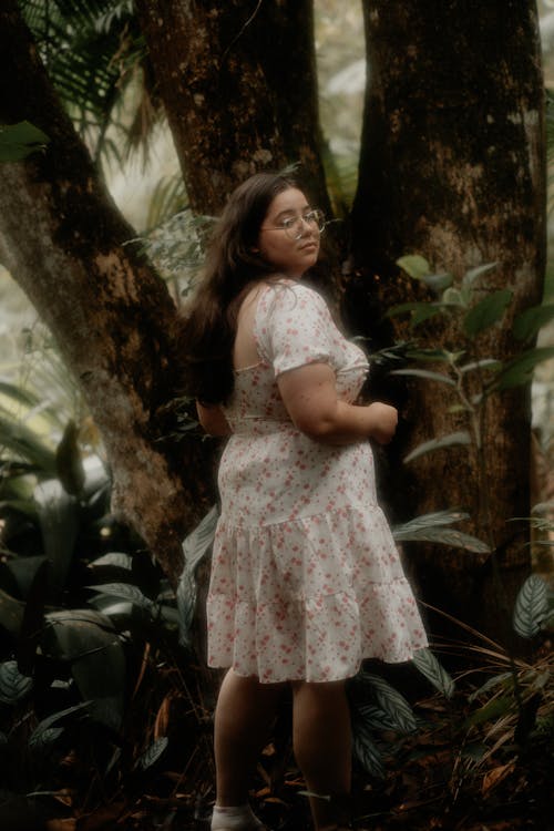 Young Woman in a Dress Standing in the Forest 