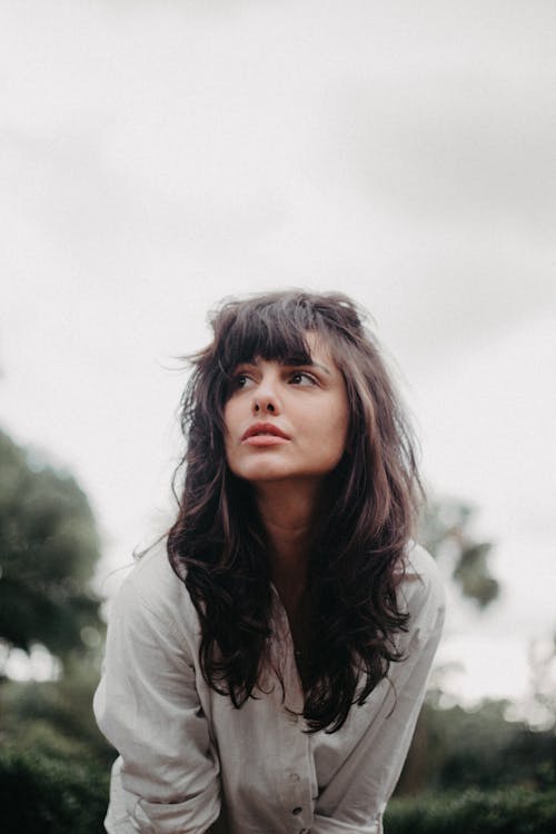 Young Brunette with Bangs Standing Outdoors 