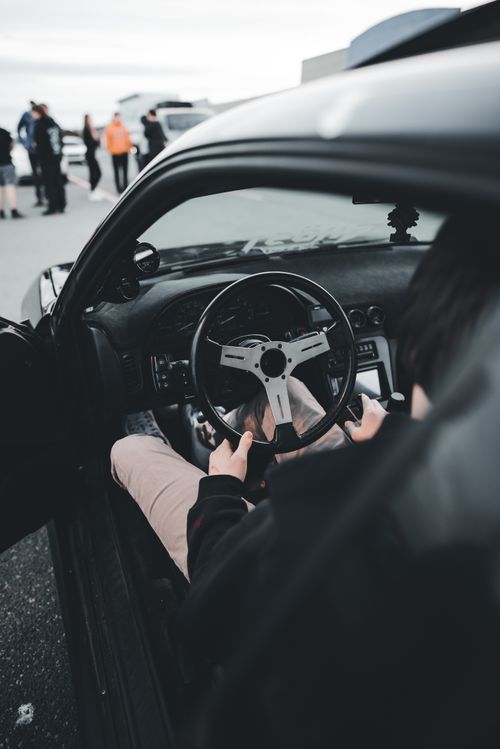 Free Close-up view of a driver inside a sports car showcasing the steering wheel and car dashboard. Stock Photo