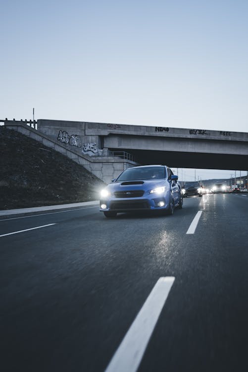 Car Driving Down the Street at Dusk