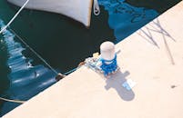 船坞的系船柱上绑着绳子，阳光下的水面一片蔚蓝