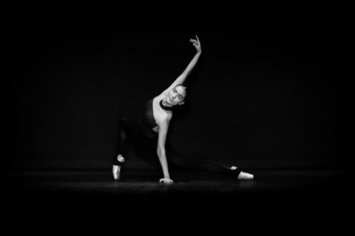 Free An elegant dancer performs a dynamic pose in black and white, showcasing grace and strength. Stock Photo