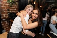 Two friends hugging and enjoying a night out in Melbourne, Australia. Lively and joyful atmosphere.