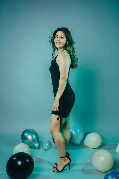 Woman Smiling and Standing Among Balloons