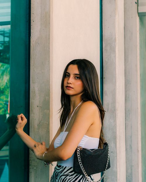 Free Young woman posing fashionably against a building in Mérida, showcasing urban style. Stock Photo