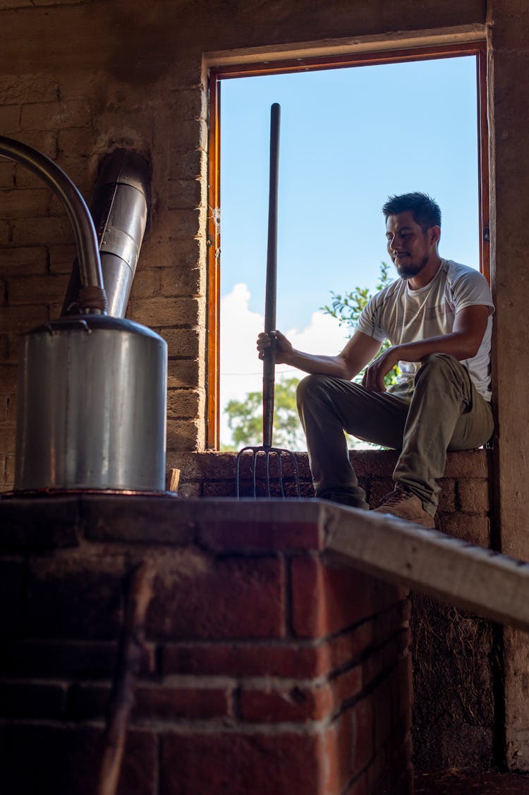 A Man Sitting In The Window Of A Distillery