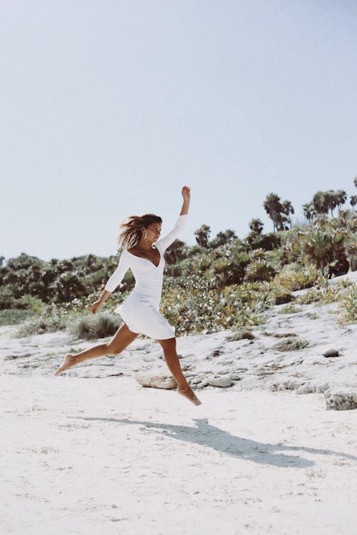 Woman in White Clothes Running on Beach
