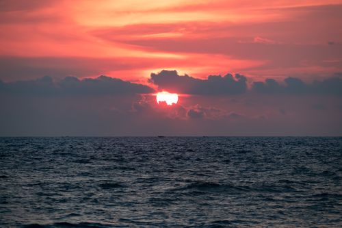 Free A mesmerizing sunset over the Arabian Sea at Kovalam Beach, featuring vivid orange hues and a serene ocean view. Stock Photo