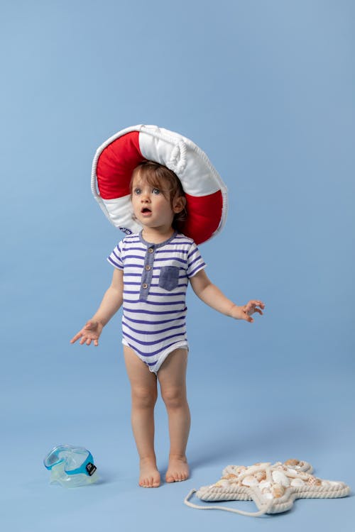 Foto Studio Anak Kecil Dengan Baju Pelampung Di Latar Belakang Biru