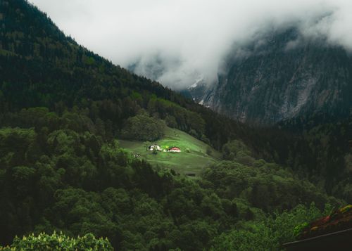 Free Tranquil aerial view of lush green valleys and misty mountains in Berchtesgaden, Germany. Stock Photo