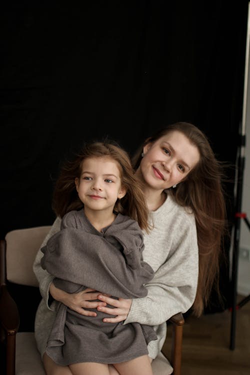 A Mother and Daughter Sitting Together on a Chair · Free Stock Photo