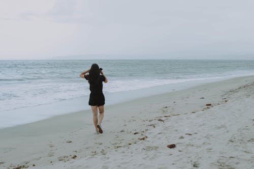 白い砂浜を歩く女性