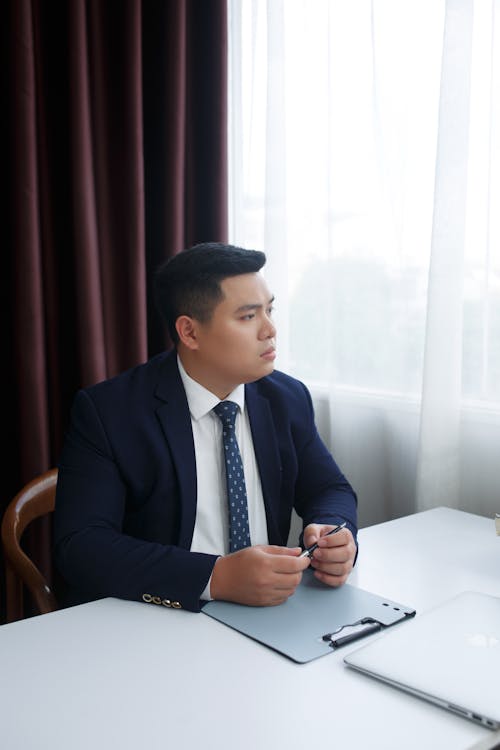 Man in a Suit Sitting behind a Desk 