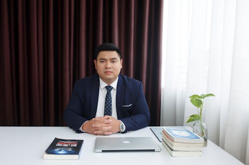 Man in a Suit Sitting behind a Desk 