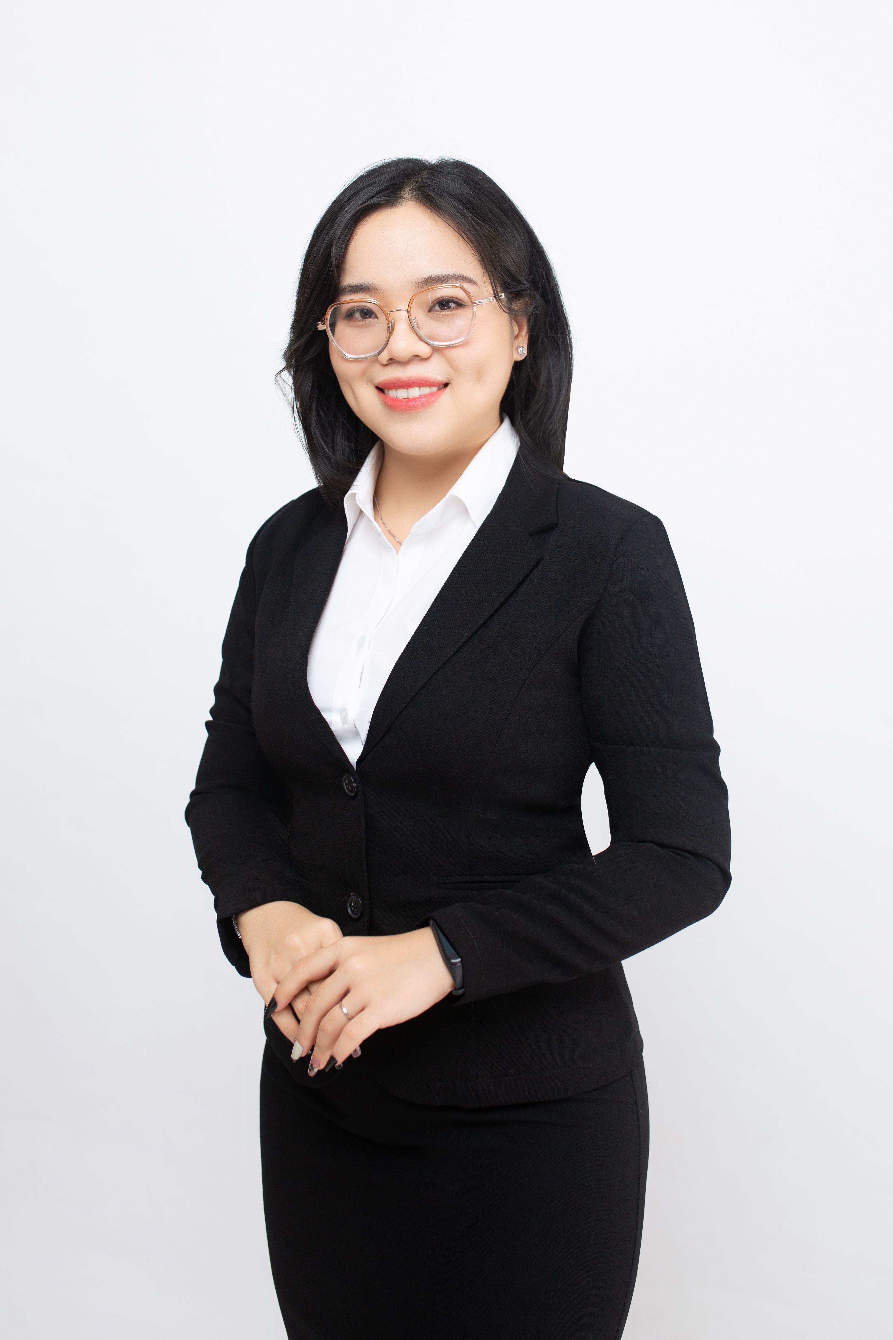 Confident businesswoman posing in elegant attire against white background.
