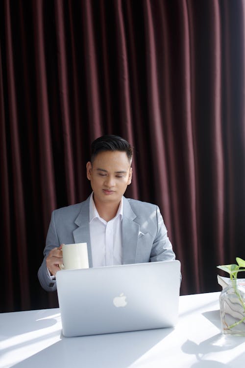 Young Man in Suit Working on Laptop